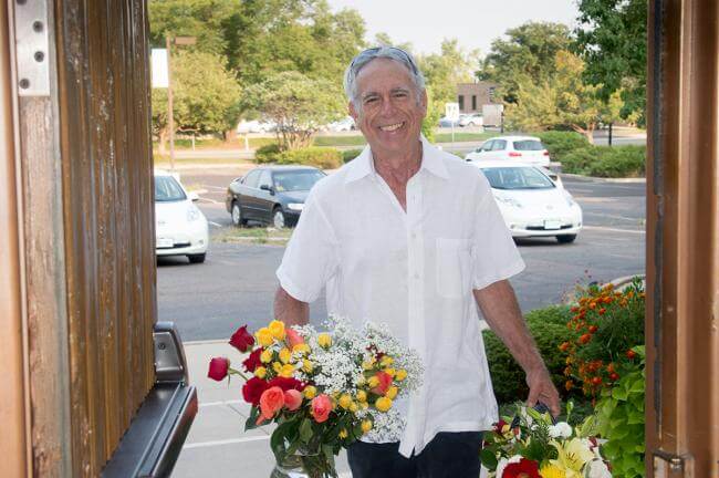 Smiling person with flowers arriving at retreat